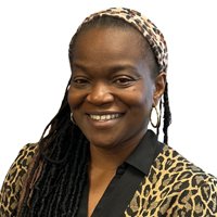 Portrait of Amirah Cutts, board member of Operation No Food Gap, smiling in a patterned blouse with a headband.