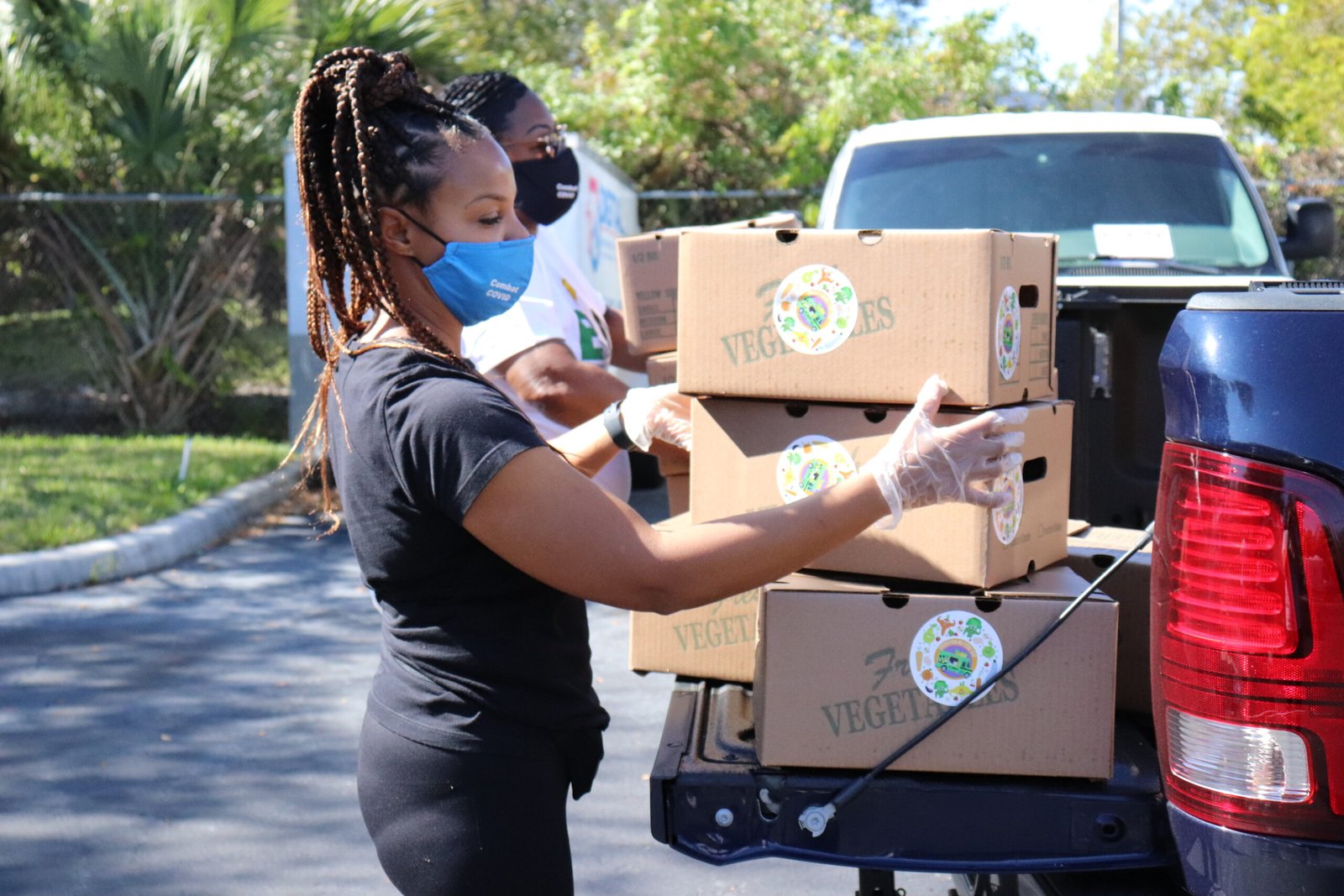 Volunteer loading boxes of fresh produce into a vehicle as part of Operation No Food Gap’s Food is Medicine program.